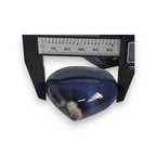 Blue translucent object with a dark interior on a white background, with a ruler for scale.