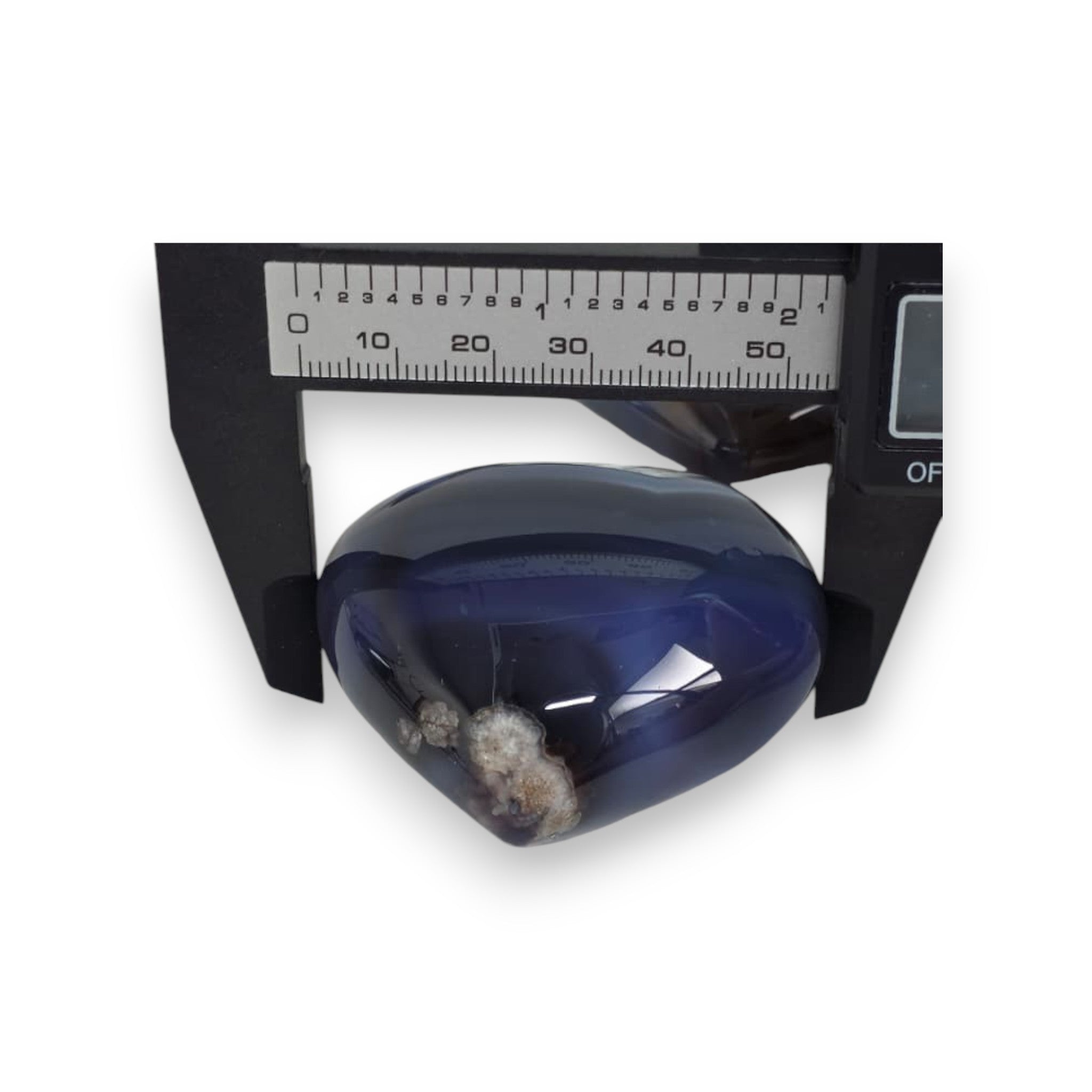 Blue translucent object with a dark interior on a white background, with a ruler for scale.