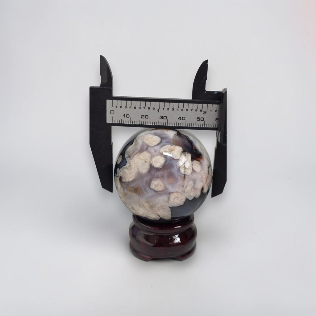 Decorative sphere with a ruler for scale on a white background