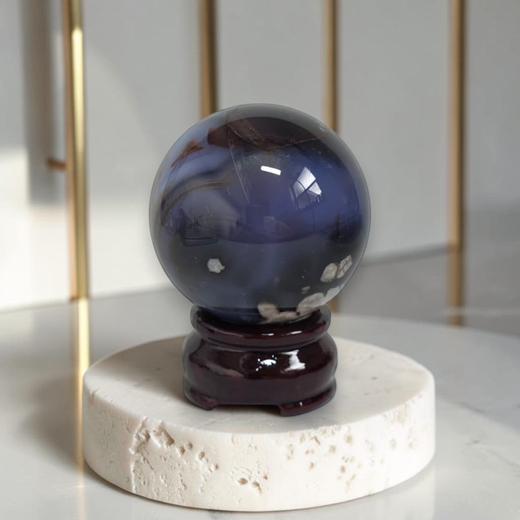 Blue crystal ball on a white pedestal with a gold frame in the background