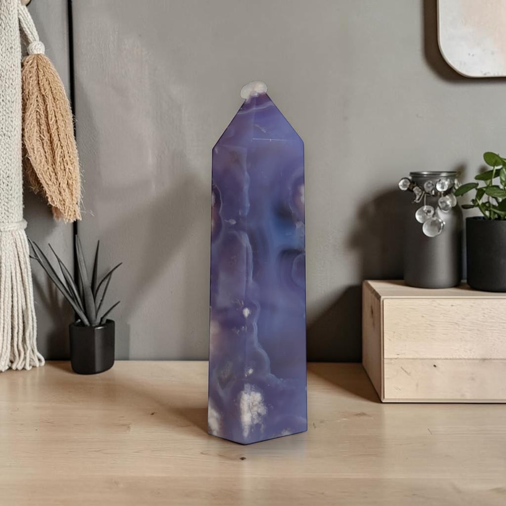Purple agate crystal on a wooden surface with a neutral background