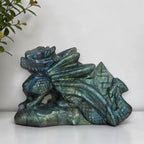 Labradorite dragon carving with blue and green flashes across its face and wings