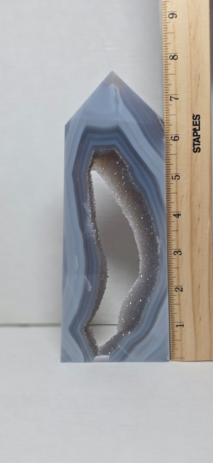 Geode crystal with a ruler for scale on a white background