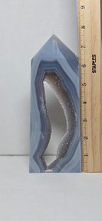 Geode crystal with a ruler for scale on a white background