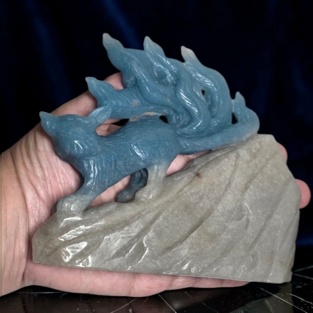 Blue trolleite nine tailed fox crystal carving held in hand showing scale