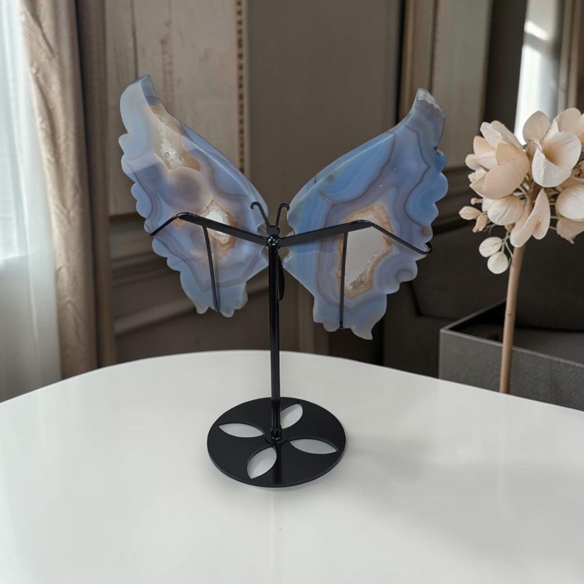 Blue agate butterfly wings crystal sculpture on black stand, front view