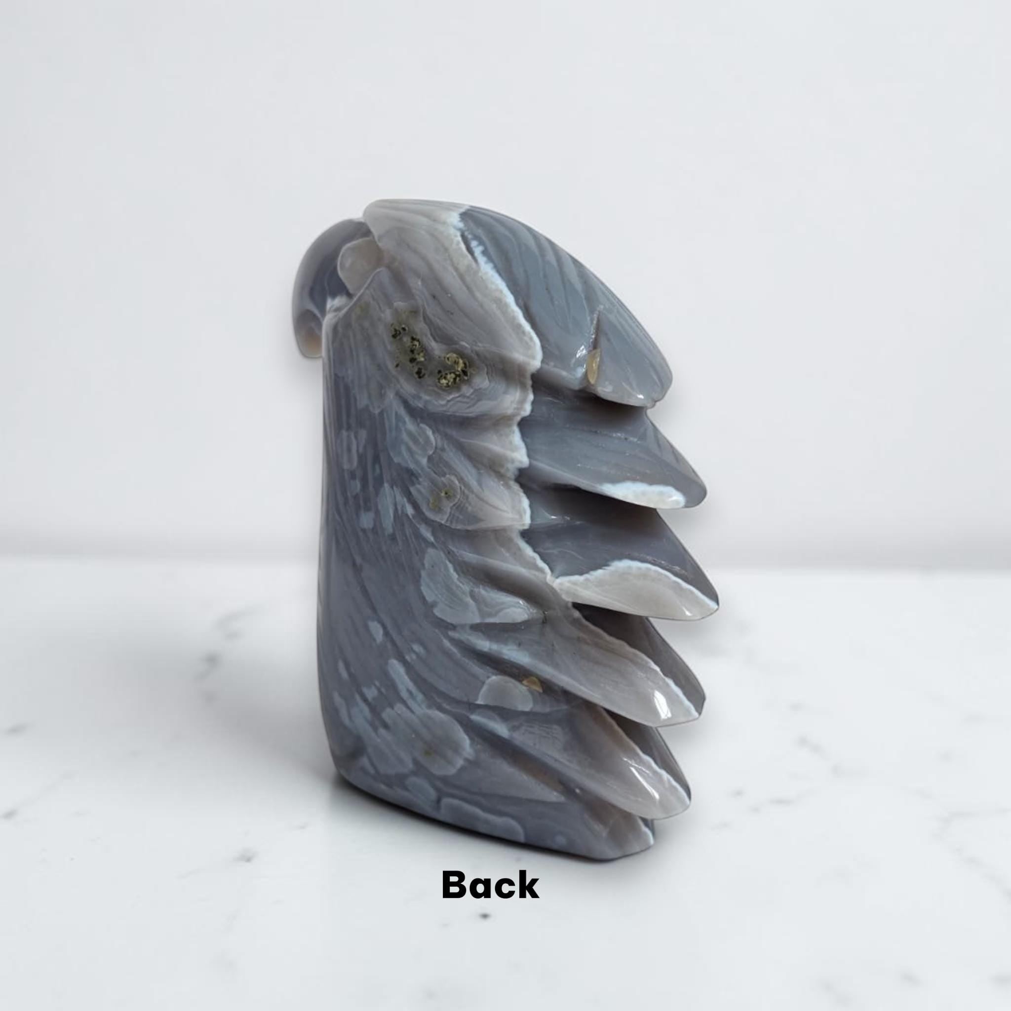 Eagle head crystal sculpture back view in glossy gray-blue stone with gemstone-like specks