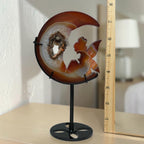 Amber moon crystal sculpture with fairy carving and druzy geode, shown on black circular base