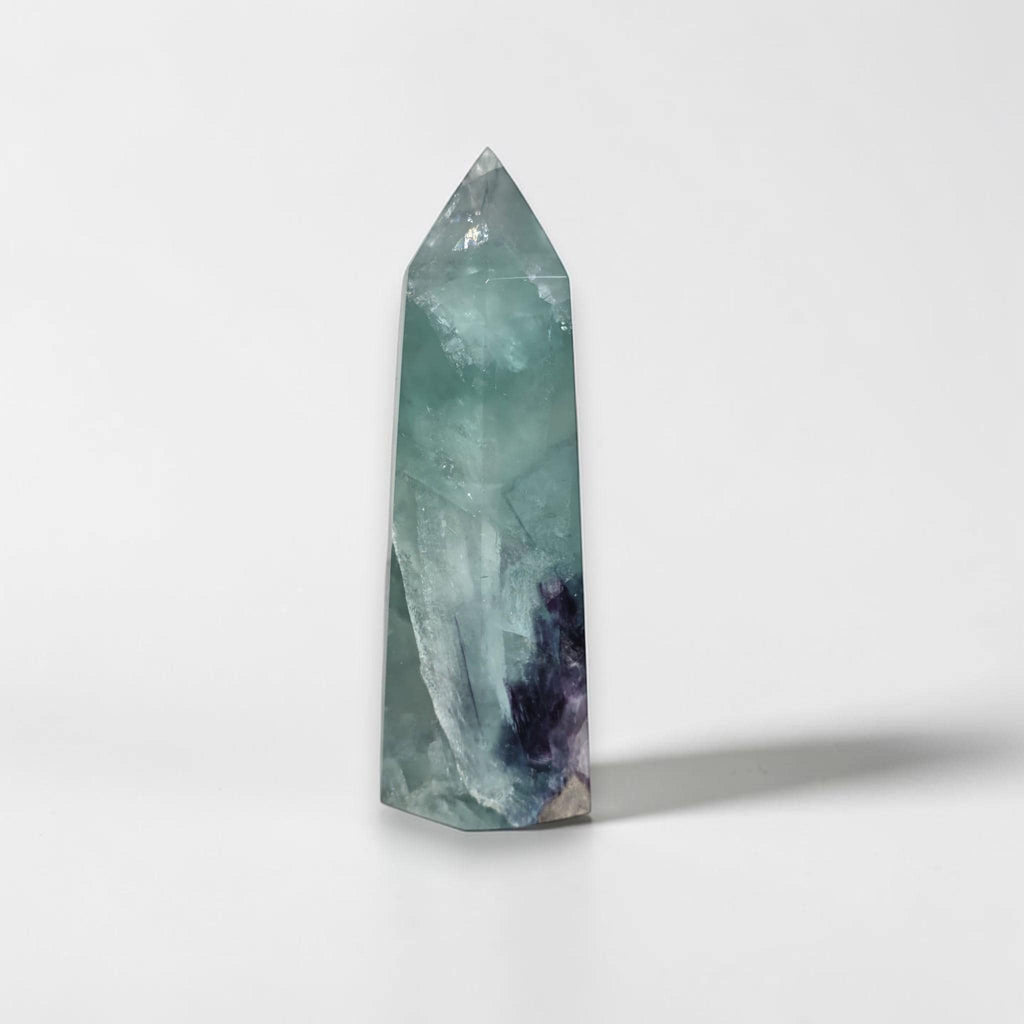 Fluorite crystal tower with pointed top, pale green body with dark purple streak