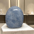 Blue calcite freeform sculpture, smooth oval stone with faceted crystal texture
