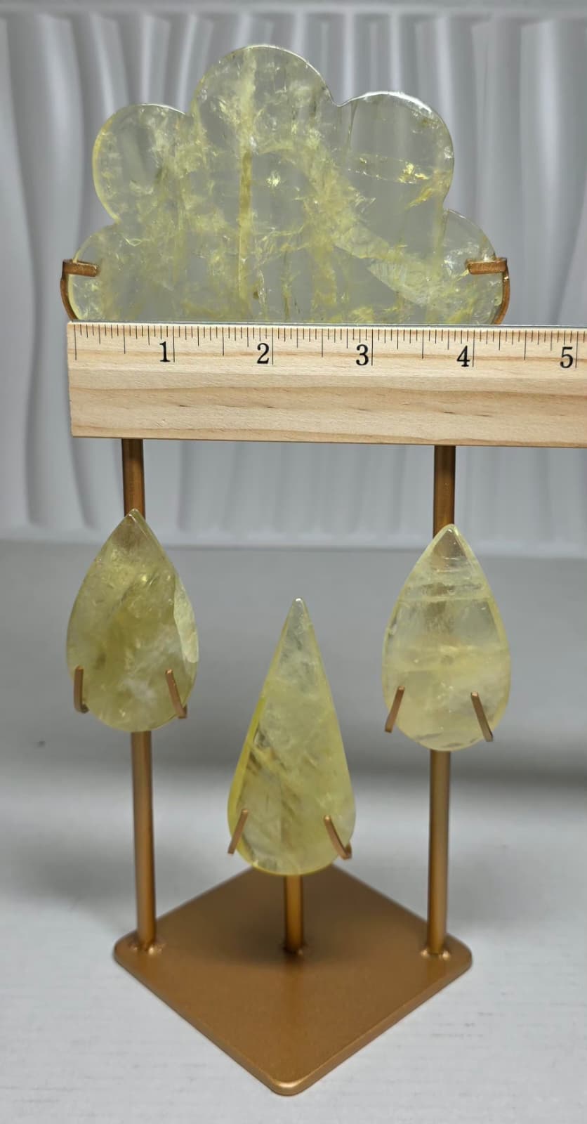 Yellow crystal sculpture with three teardrop pieces on gold metal stand