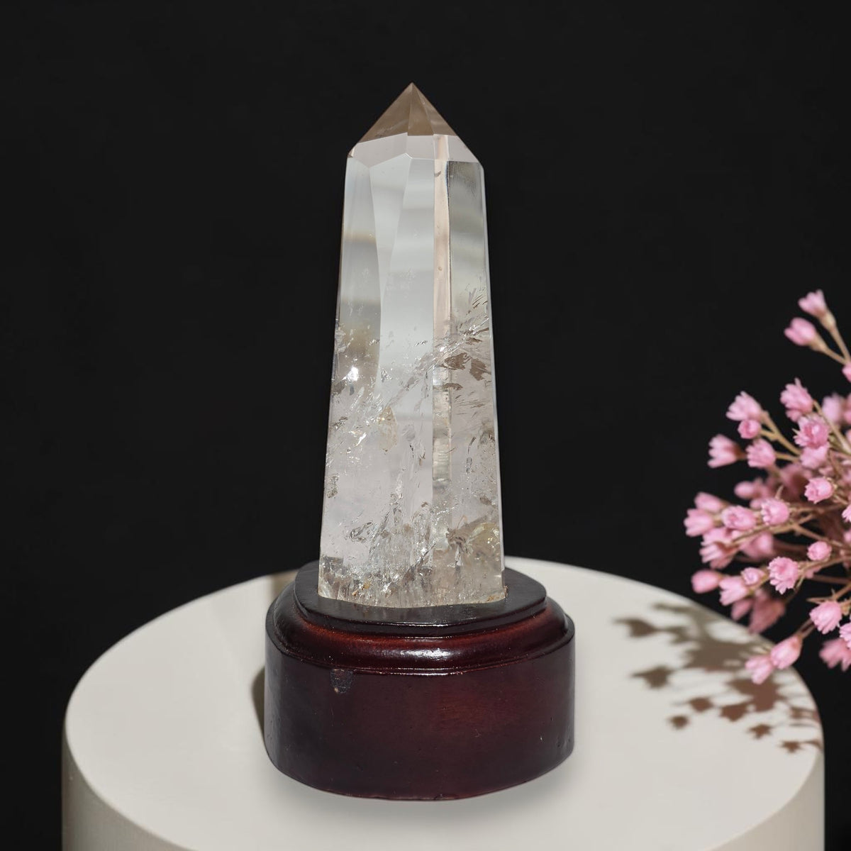 Clear quartz tower beside ruler showing approximately 5.5 inches with stand