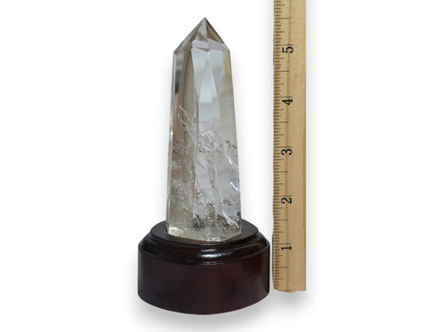 Clear quartz obelisk tower on dark display stand, front view