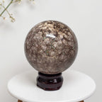 Coral jasper sphere 80mm on dark stand, mottled brown with vein texture