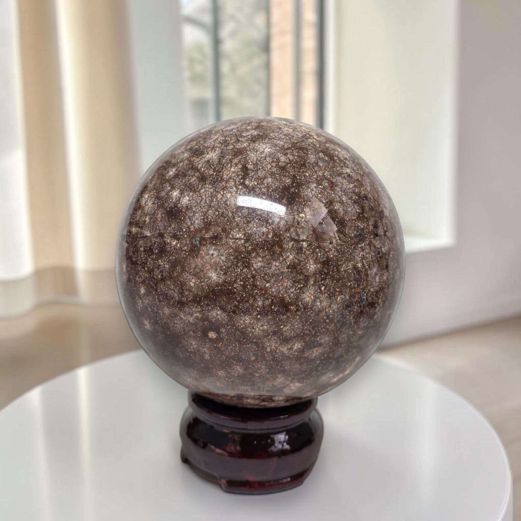 Coral jasper sphere 80mm on dark stand, speckled brown and gray veining