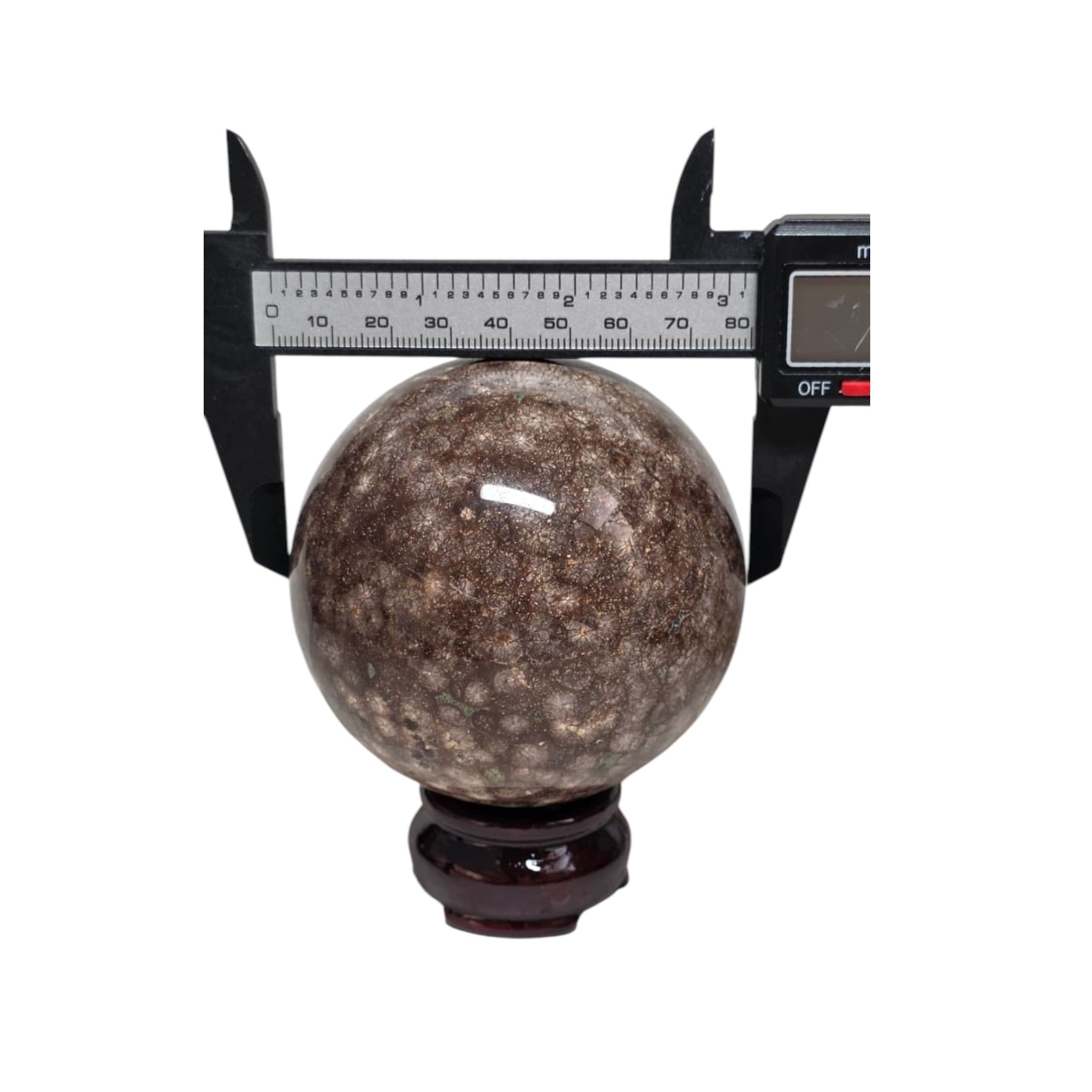 Coral jasper sphere 80mm on dark stand, size shown with calipers