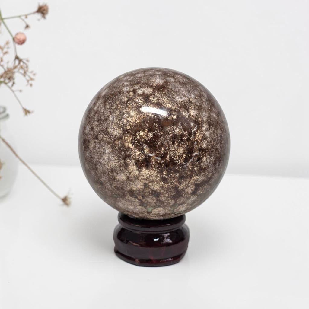 Coral jasper sphere 80mm on dark stand, dark brown mottled surface with flecks