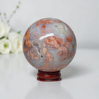 Agate sphere on stand, cloudy blue-gray with orange mineral patches