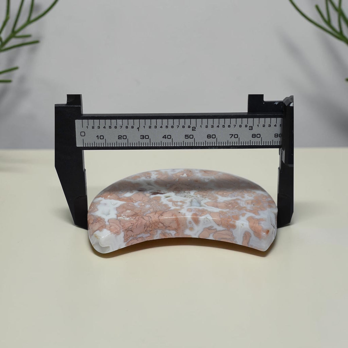 Cotton Candy Agate moon shown with measuring caliper