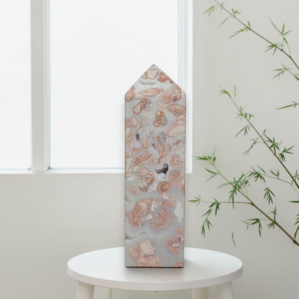 Pink and cream patterns on Cotton Candy Agate tower held in a gloved hand