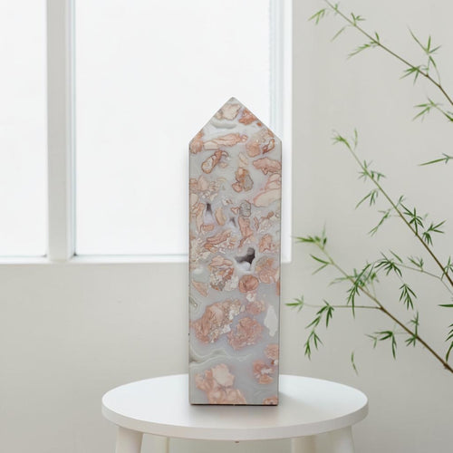 Pink and cream patterns on Cotton Candy Agate tower held in a gloved hand