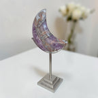 Purple banded agate crescent moon on silver stand, angled view
