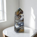 Polished ocean jasper obelisk with white swirls, blue-gray tones and brown-gold streaks