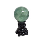 Green fluorite sphere on dark ornate pedestal, rounded glossy stone