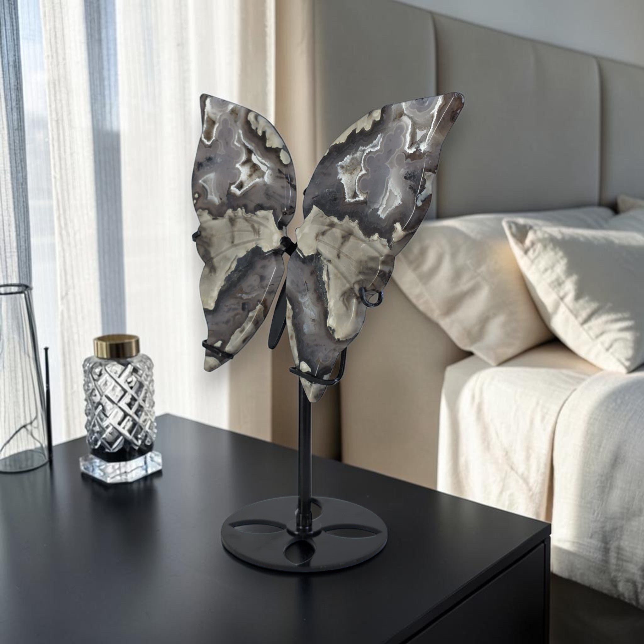 Butterfly sculpture on a stand in a bedroom setting