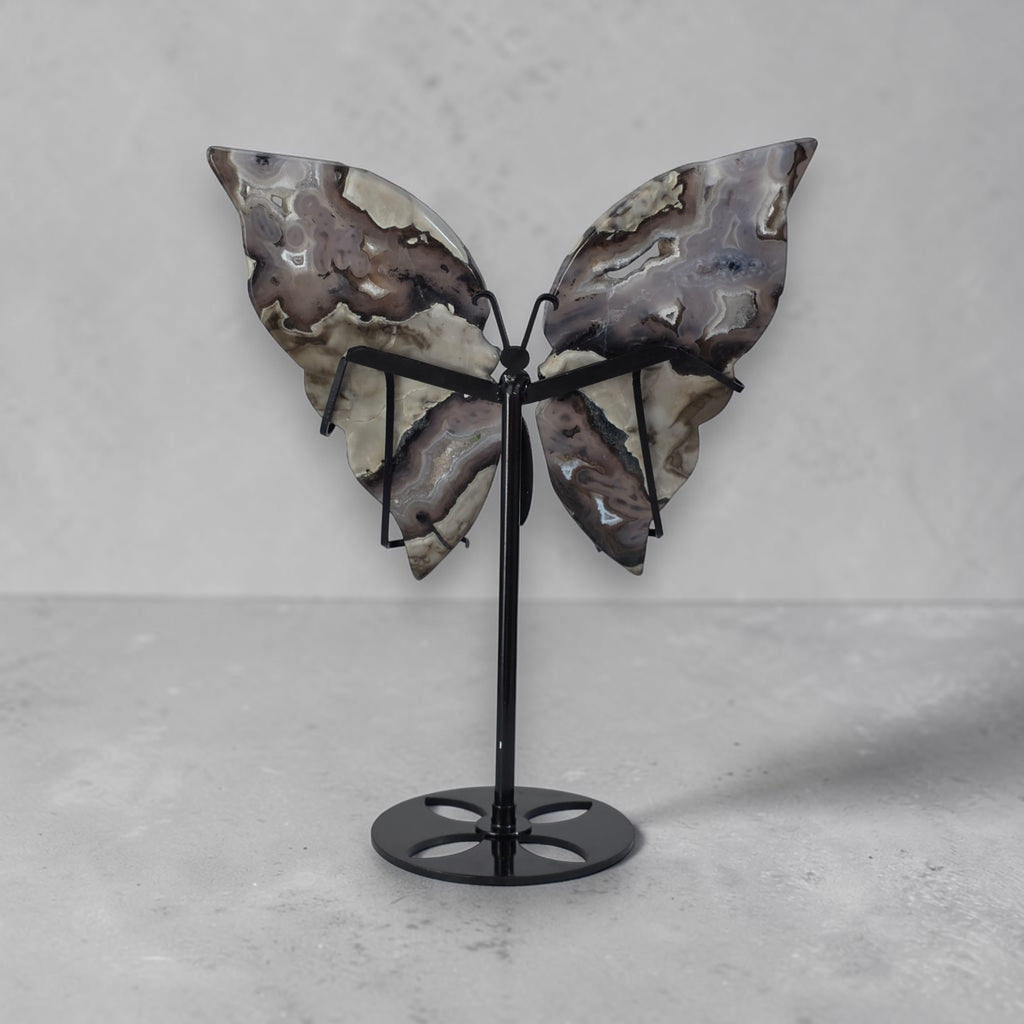 Butterfly sculpture on a stand against a gray background