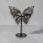 Butterfly sculpture on a stand against a gray background