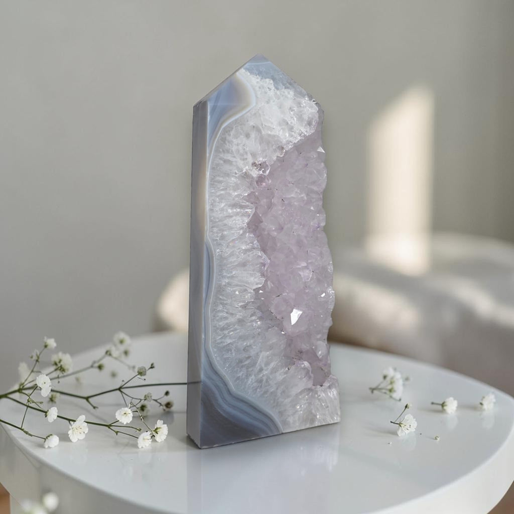 Geode crystal on a white surface with small white flowers