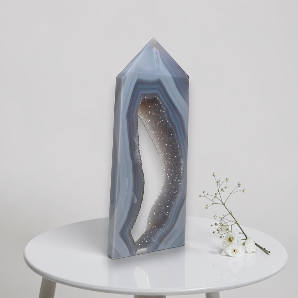 Geometric crystal sculpture on a white table with a minimal background