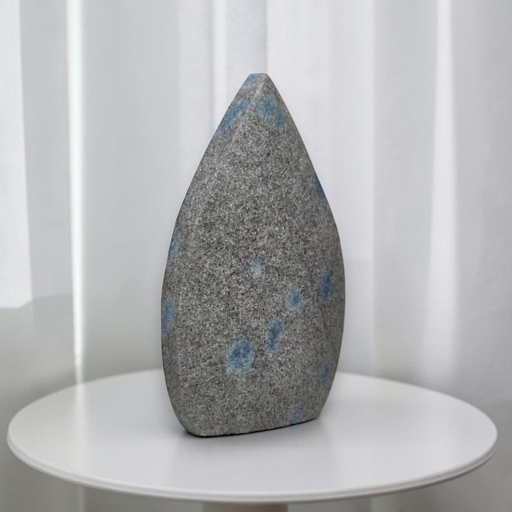Teardrop polished stone, gray with blue spots, pointed top and smooth base