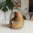 Flame-shaped ocean jasper crystal on display; blue-gray center with reddish-brown swirls