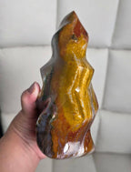 Polished flame-shaped jasper crystal, glossy yellow-gold center with dark edges