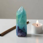 Fluorite crystal tower with pointed top, aqua green facets and dark purple base