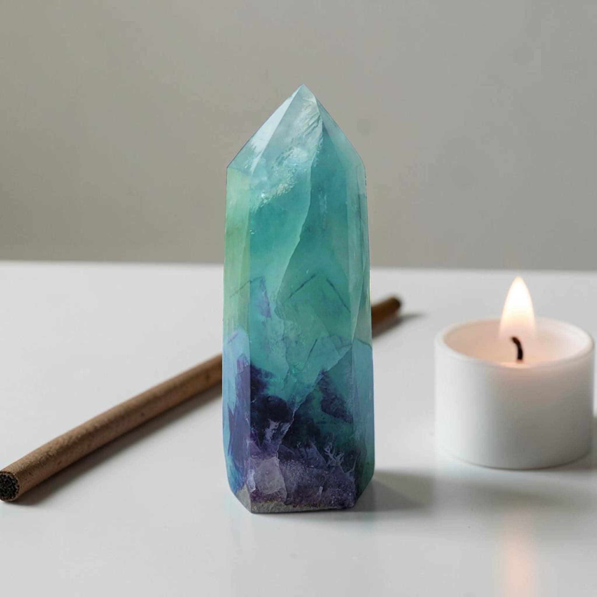 Fluorite crystal tower with pointed top, aqua green facets and dark purple base