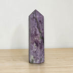Purple lepidolite obelisk tower with faceted sides, pointed top, and veining