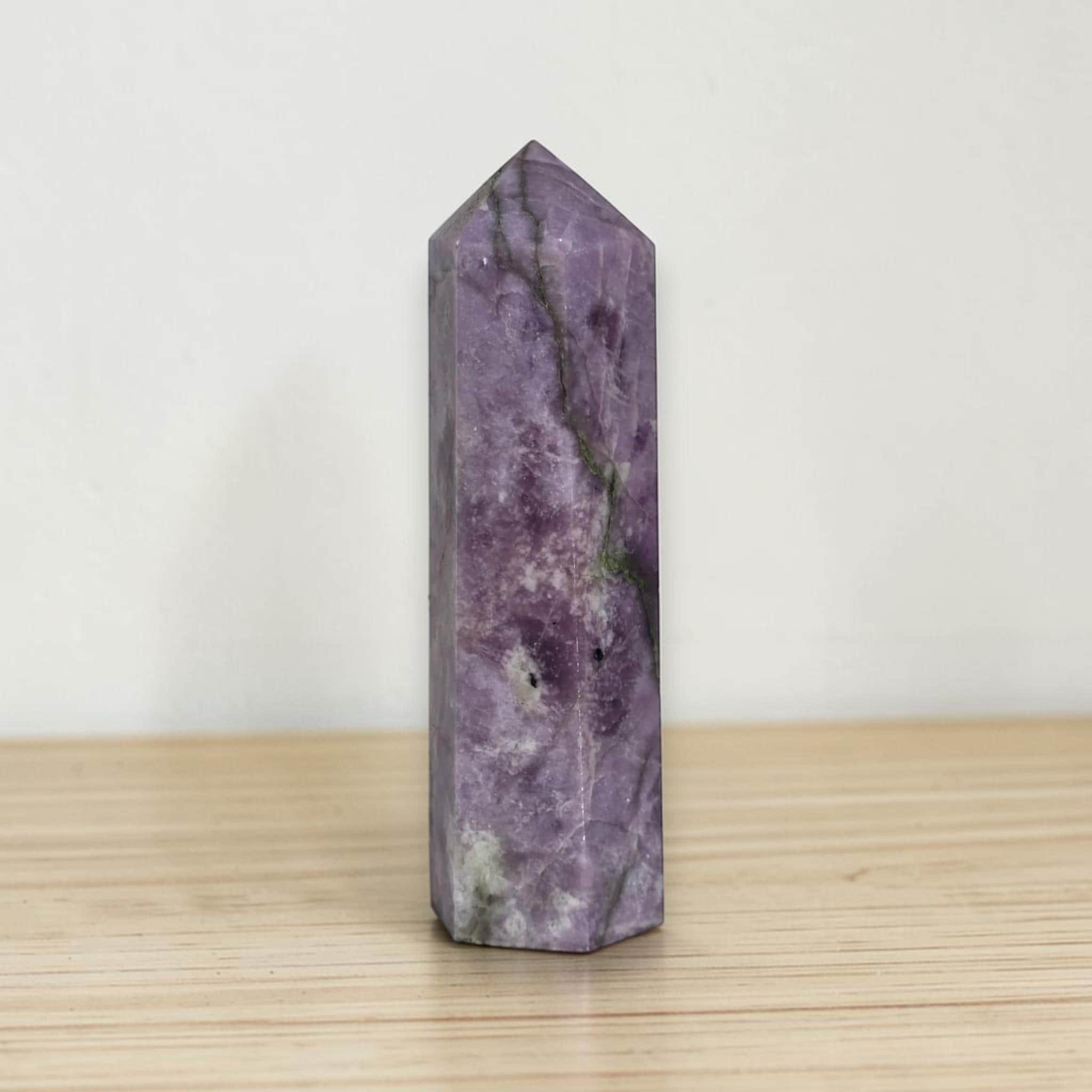 Purple lepidolite obelisk tower with faceted sides, pointed top, and veining