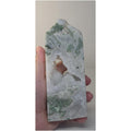 Green moss agate crystal obelisk with white druzy interior and green patches, tall.
