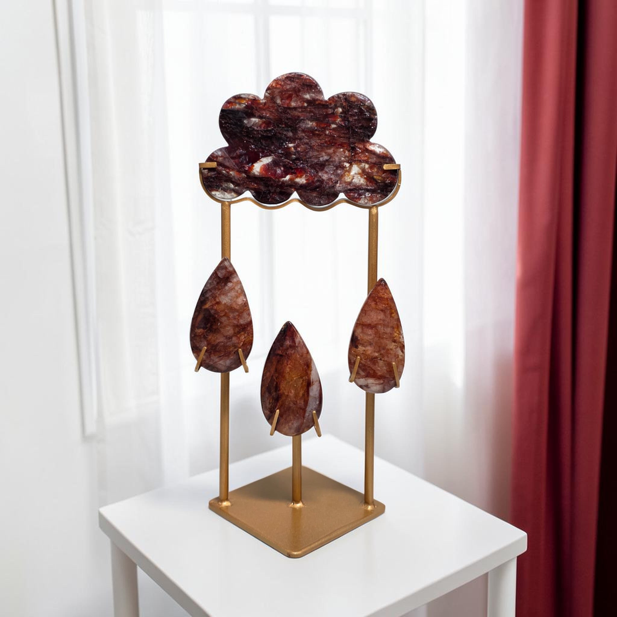 Fire quartz storm cloud and raindrops sculpture on gold metal stand front view