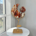 Fire quartz crescent moon with flower on gold-tone stand