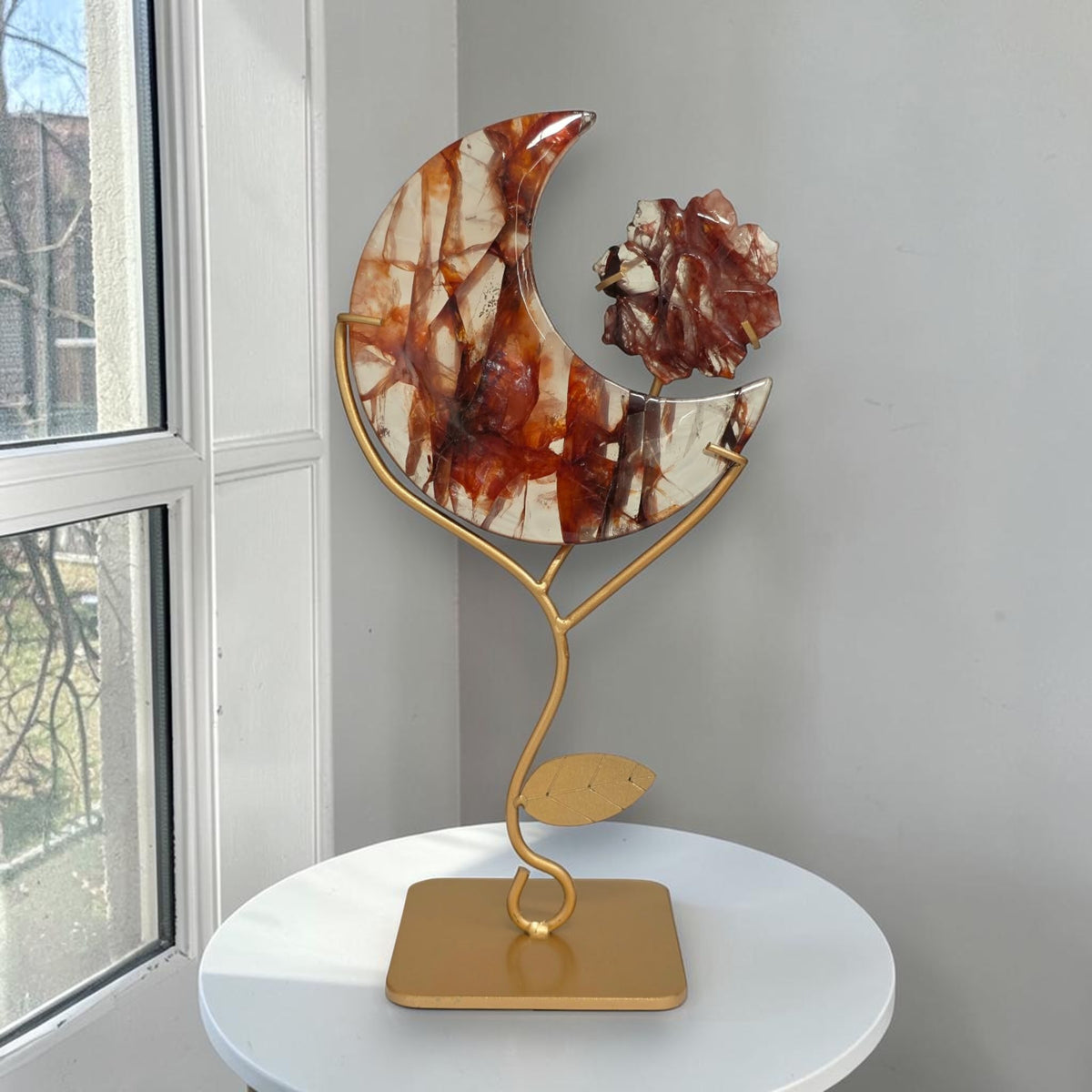 Fire quartz crescent moon with flower on gold-tone stand
