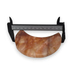 Crescent moon quartz crystal with black caliper measurement, orange and cream marbling