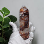 Fire Quartz tower held in gloved hand showing red and white natural patterns