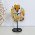 Golden Healer quartz angel wings and heart on a black display stand