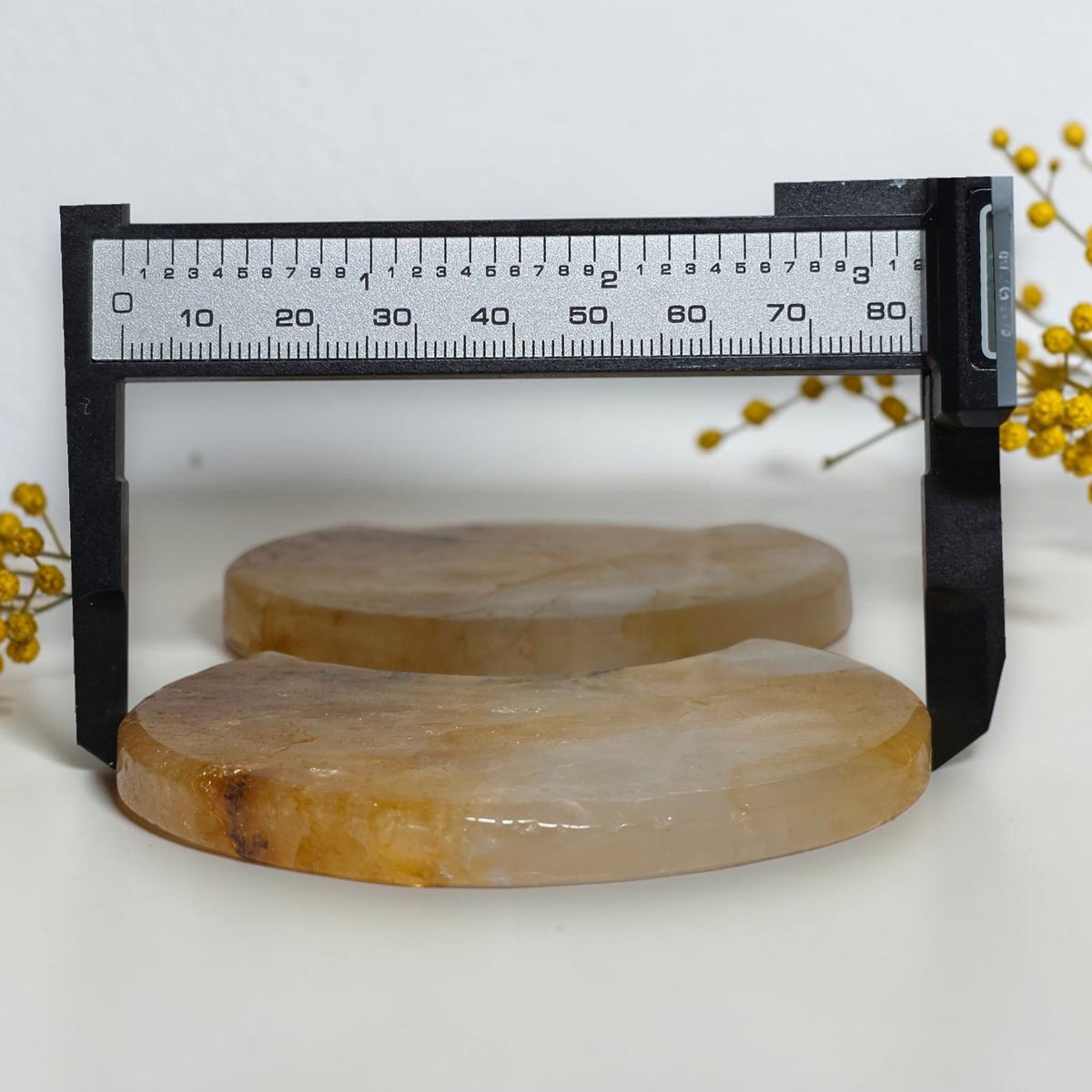 Crescent quartz moon carvings beside a caliper