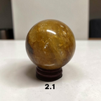 Golden Healer Quartz crystal sphere on wood stand white background