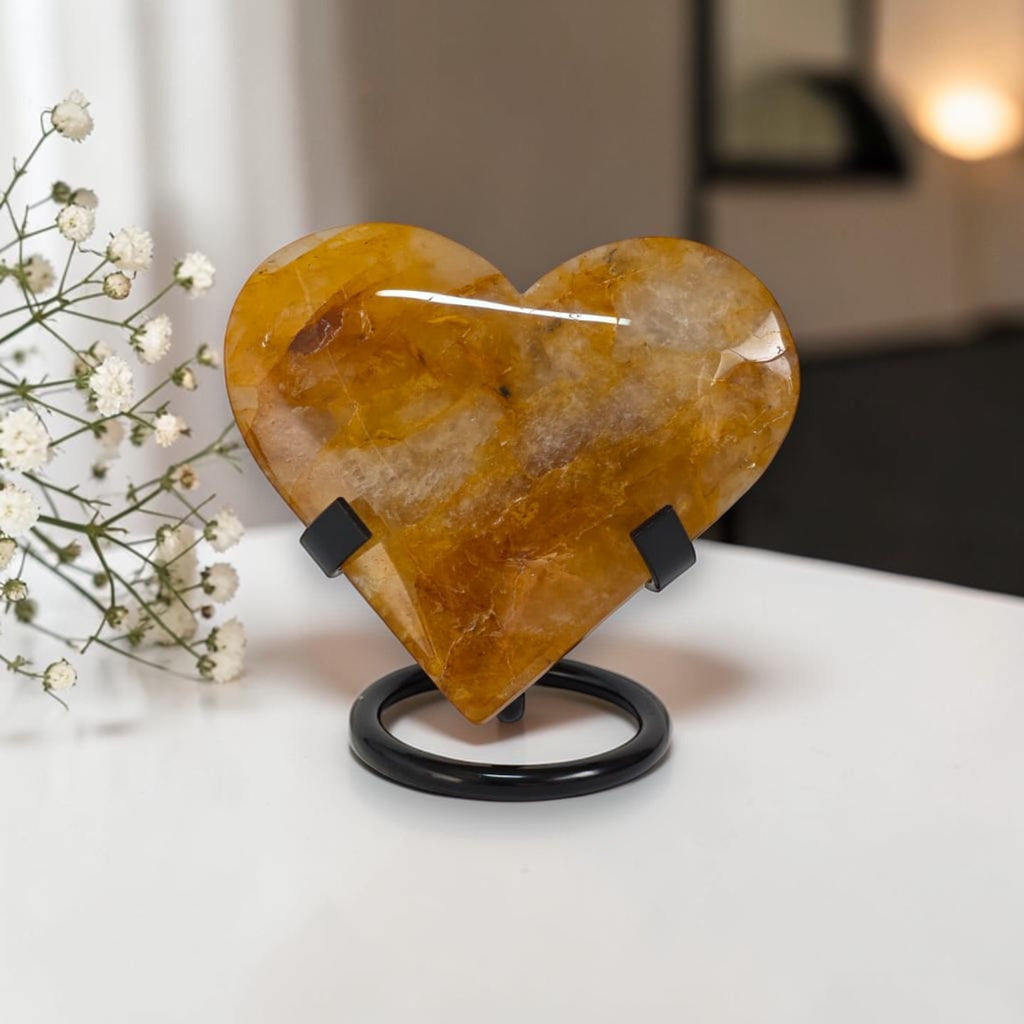Heart-shaped stone on a stand with white flowers in the background